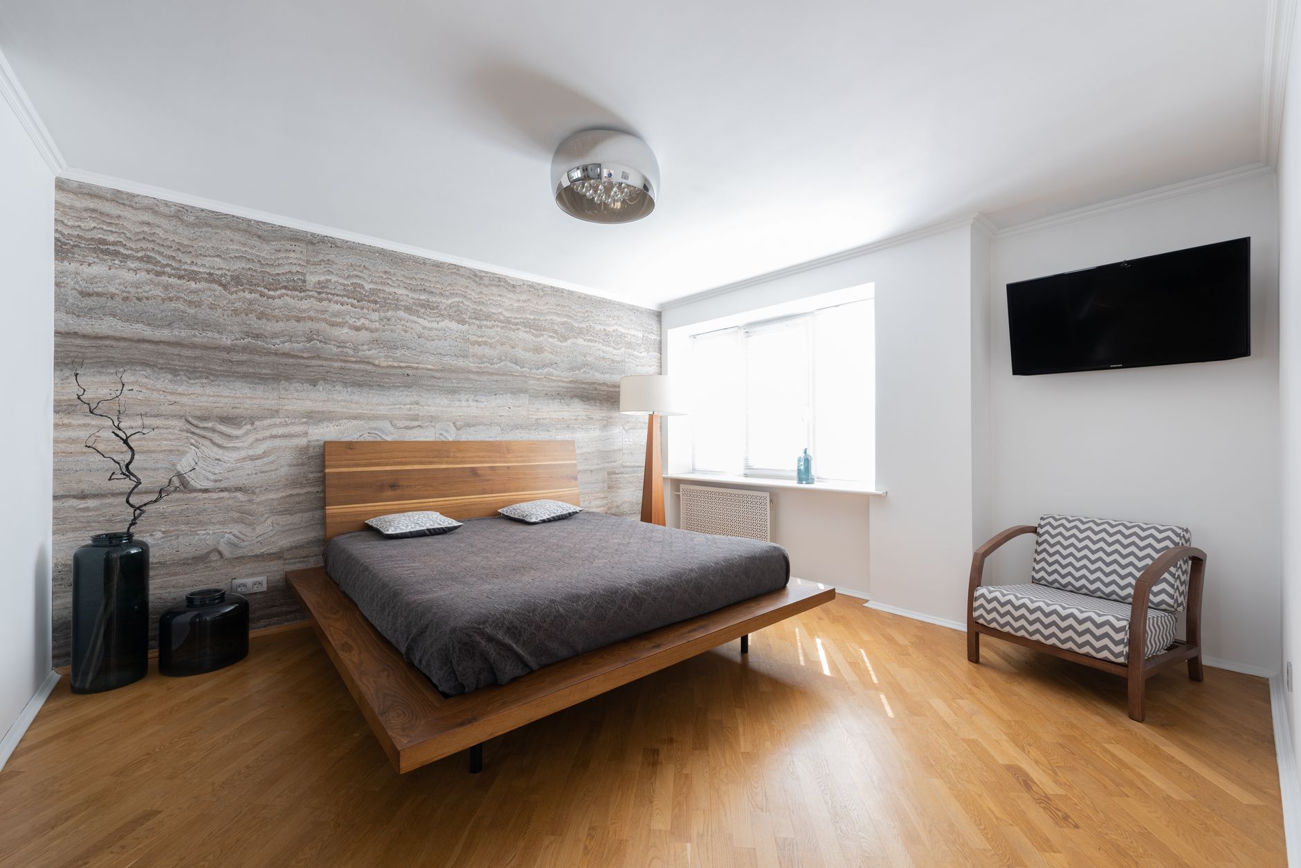 Bilik tidur dengan katil platform kayu walnut dan kerusi berangka kayu